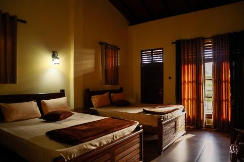 een slaapkamer met twee bedden en een raam bij The Hidden Heaven in Diyatalawa