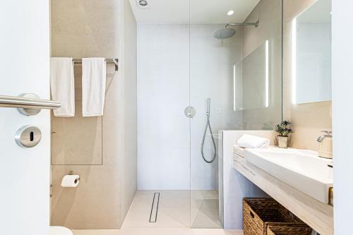 ein weißes Badezimmer mit Waschbecken und Dusche in der Unterkunft salgado`s nest in Portimão