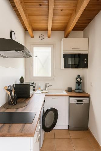 une cuisine avec des armoires blanches et un évier dans l'établissement Le numéro 3, à Mirepeisset