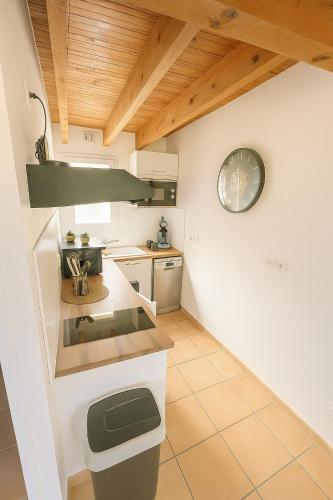 une cuisine avec un comptoir et une horloge au mur dans l'établissement Le numéro 3, à Mirepeisset