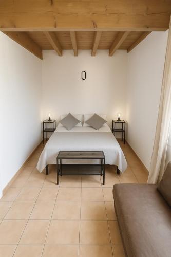 - une chambre avec un lit blanc et deux tables de chevet dans l'établissement Le numéro 3, à Mirepeisset