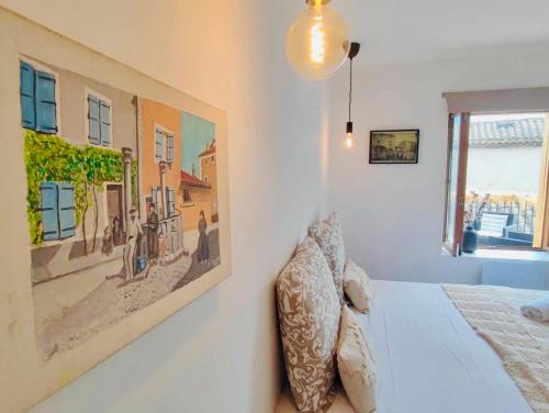 une chambre avec un lit avec un tableau sur le mur dans l'établissement L'appart Tomey, à Carcassonne