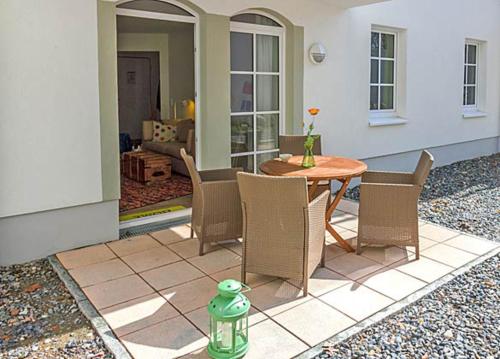 a patio with a table and chairs and a green fire hydrant at Haus Meeresblick - Ferienwohnung Stoertebeker A 0.17 (Ref. 138715 u1) in Baabe