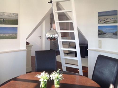 ein Esszimmer mit einer Treppe, einem Tisch und Stühlen in der Unterkunft Inselresidenz Strandburg - Ferienwohnung 305 (Ref. 50973) in Juist