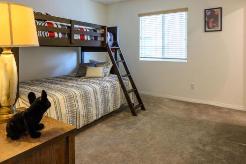 a bedroom with a bunk bed with a black dog sitting on a table at 6BR Villa with POOL, BBQ, Temecula WINERIES in Winchester