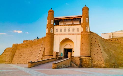 a large brick building with a gate and steps at Otkirbek hotel boutique in Bukhara