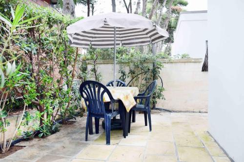a table with two chairs and an umbrella at Camping Villaggio Pineta Al Mare in Specchiolla 