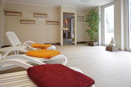 a living room with white chairs and orange pillows at Haus Meeresblick - Ferienwohnung Meerblick (Ref. 128699) in Baabe