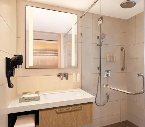 a bathroom with a sink and a shower at Hilton Garden Inn Surat City Centre in Surat