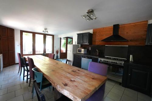 une cuisine avec une table en bois et quelques chaises dans l'établissement Loz'aire naturelle, à Quézac