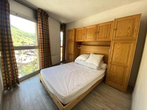 une chambre avec un lit et une grande fenêtre dans l'établissement Résidence Diamant 1 - Chaleureux T3 centre station, avec vue sur les pistes MAE-5381, à Vénosc
