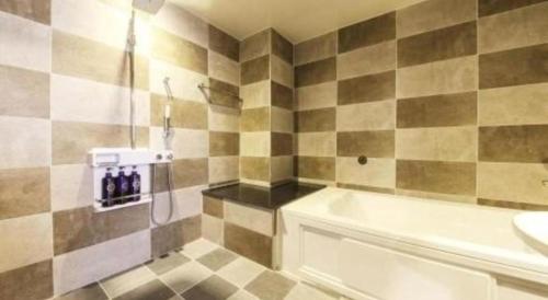 a bathroom with a shower and a tub and a sink at H Hotel in Ulsan