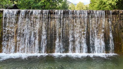 a waterfall in the middle of a pool of water at River house HRIB in Preddvor