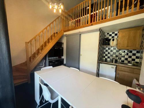 une cuisine avec une table blanche et un escalier dans l'établissement Résidence Arc En Ciel C - Duplex coup de coeur en hauteur de station MAE-5441, à Vénosc