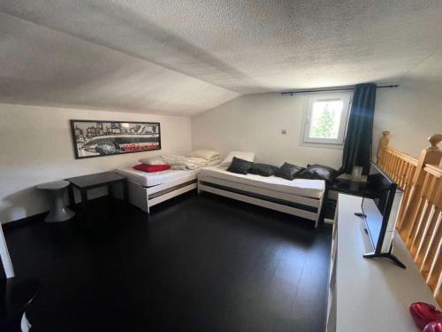 un salon avec deux lits et une table dans l'établissement Résidence Arc En Ciel C - Duplex coup de coeur en hauteur de station MAE-5441, à Vénosc