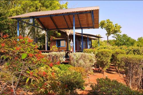 a house with a wooden roof in a garden at Golan Cabins in Had Nes