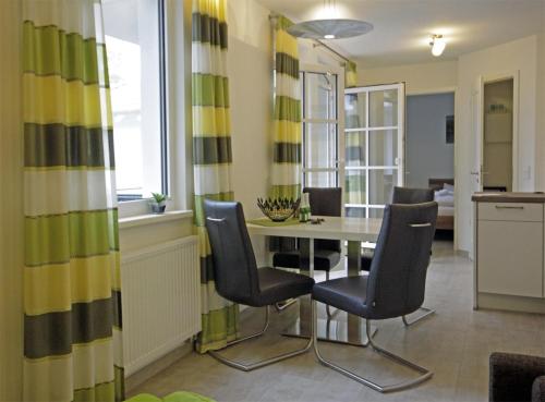 a kitchen and dining room with a table and chairs at Haus Meeresblick - Ferienwohnung Am Strand (Ref. 128682u1) in Baabe