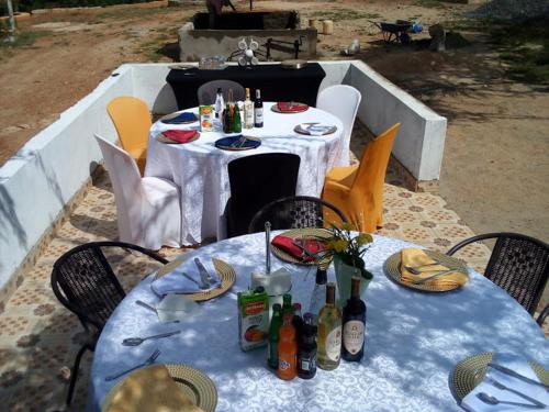 a table with chairs and bottles of alcohol on it at Nthike Eco Cottages & Campsite in Kangundo