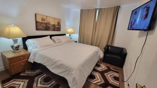 カルガリーにある3 Bedroom House Near Airport and Downtownのベッドとテレビのある小さな寝室