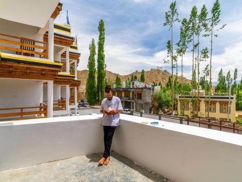 a man standing on the ledge of a building at Hotel Bayshu - The Hosteller Leh in Leh