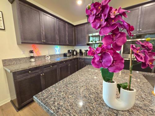 a kitchen with a counter with purple flowers in a vase at 6BR Villa with POOL, BBQ, Temecula WINERIES in Winchester