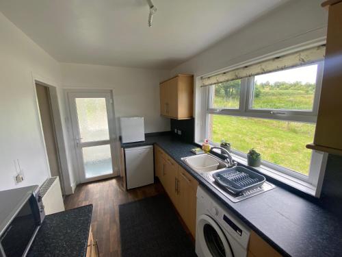 a small kitchen with a sink and a window at Alltachbeg in Tomintoul