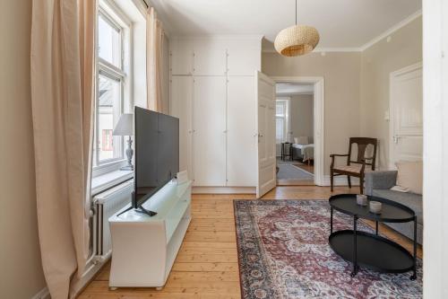 un salon avec une télévision et une table dans l'établissement Well-planned 1 bedroom apartment in central Visby, à Visby