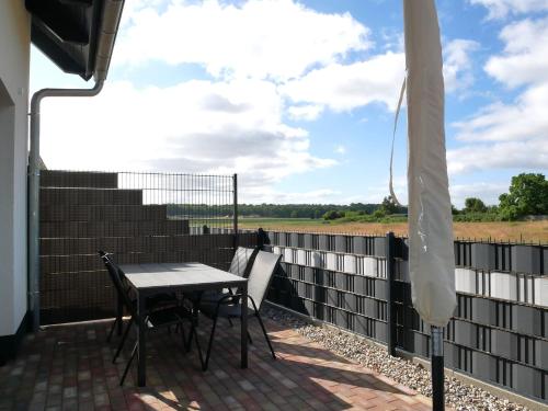 a table and chairs on a patio with a fence at Kelm's Küstennest 1 - 5 Fahrradminuten vom Strand entfernt in Kolpinsee