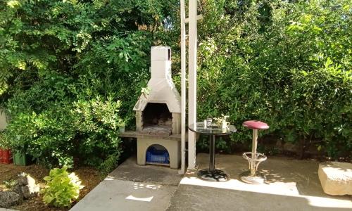 a dog house with a table and a stool at Apartman Vlatka in Kninsko Polje