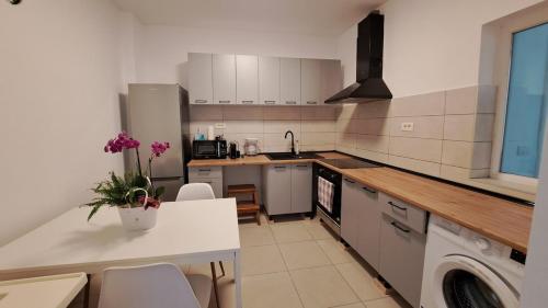 a kitchen with white appliances and a table and chairs at Cosy House 400 m from Iulius Town in Timişoara