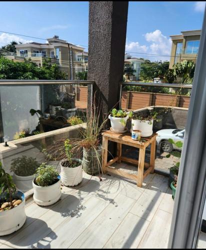 a balcony with several potted plants and a table at Lakefront Luxury Retreat Munyonyo in Kampala