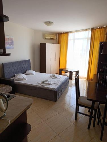 a bedroom with a bed and a table and chairs at PSB Apartments in Midia Resort Aheloy in Aheloy