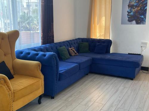 a blue couch and a chair in a living room at Lakefront Luxury Retreat Munyonyo in Kampala