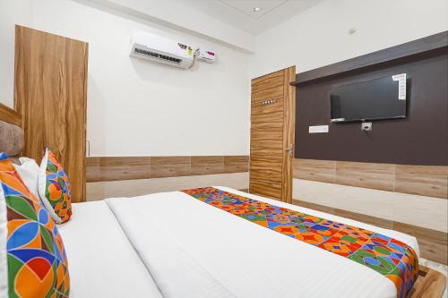 a bedroom with a bed and a flat screen tv at FabHotel Devi Heritage - 2 kms from Shri Banke Bihari Mandir in Vrindāvan