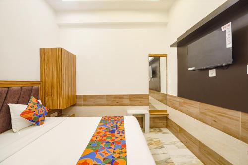 a room with a bed and a flat screen tv at FabHotel Devi Heritage - 2 kms from Shri Banke Bihari Mandir in Vrindāvan