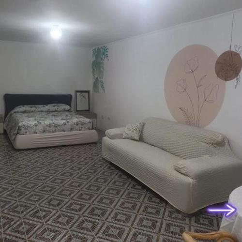 a bedroom with a bed and a couch in it at Villa Antonella in Monte SantʼAngelo