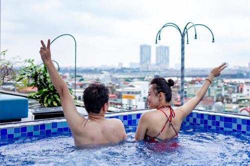 a man and a woman in a swimming pool at Shining Central Hotel & Spa in Hanoi