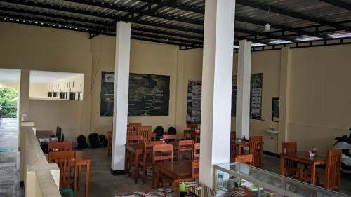 a dining room with wooden tables and chairs at Rinjani Homestay Senaru in Senaru