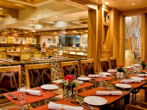 a dining room with a long table and chairs at Clarion Bella Casa at Airport in Jaipur
