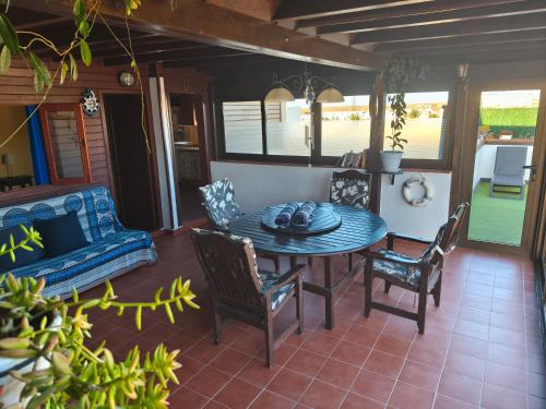 a patio with a table and chairs and a couch at Casa Orymar in Cotillo