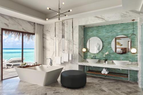 a bathroom with two sinks and a tub and a mirror at Niyama Private Islands Maldives in Dhaalu Atoll