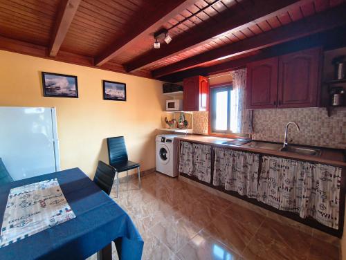 a kitchen with a sink and a table and a counter at Casa Orymar in Cotillo