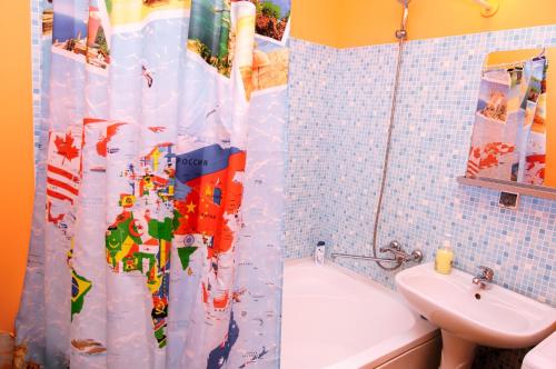 a bathroom with a shower curtain with a toilet and a sink at Yin Yang in Moskva Complex in Yekaterinburg