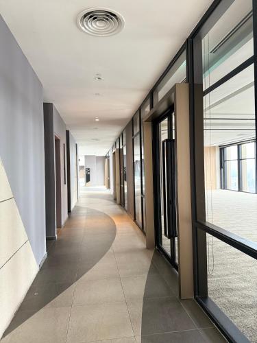 a hallway of an office building with glass doors at Axon Suite Bukit Bintang By Luna in Kuala Lumpur