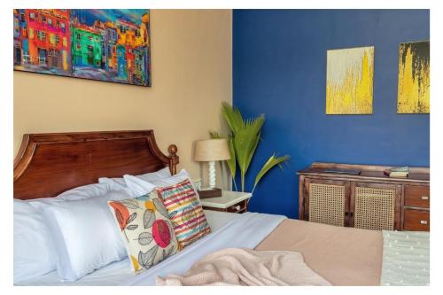 a bedroom with a bed with a blue wall at Dia Hotels and Homes Nerul Goa - Villas and Apartments in Nerul