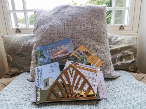 a pile of books on a bed with a pillow at Deeley House in Matlock