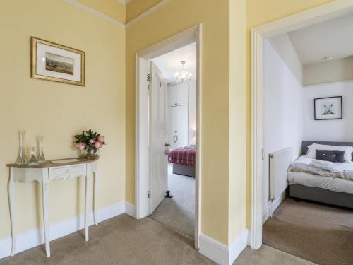 a bedroom with yellow walls and a bed and a mirror at Deeley House in Matlock