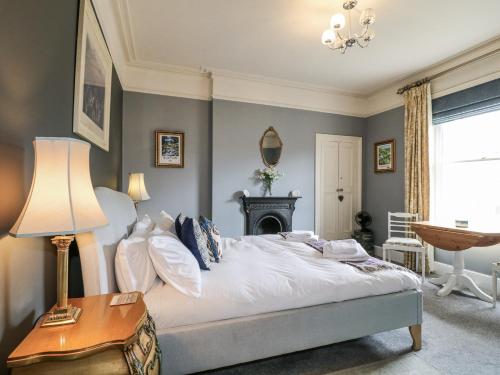 a bedroom with a bed and a table with a lamp at Deeley House in Matlock