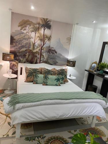 a bedroom with a large bed with a painting on the wall at Casa Manalo Guest House in Puerto Princesa City
