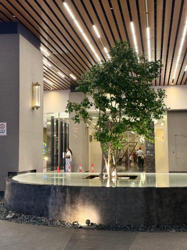 a building with a tree in the middle of a lobby at Axon Suite Bukit Bintang By Luna in Kuala Lumpur